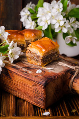 Obraz na płótnie Canvas Traditional arabic sweets walnuts baklava on wooden vintage background with springs flowers. Selective focus. 