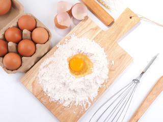 eggs, wheat flour, whisk, wooden table on white background