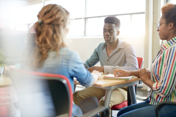 Unposed group of creative business people in an open concept office brainstorming their next project.