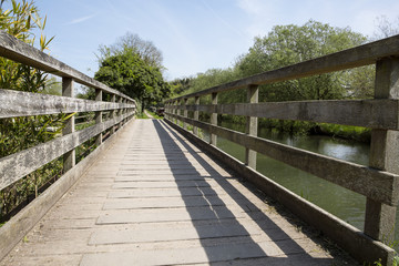 Fototapeta na wymiar Bridge. A bridge across a little inlet to the Kennet and Avon canal in Berkshire. The bridge is well maintained and is used as a public walkway for country strolls.