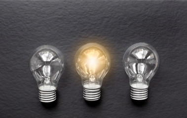 three concept of idea illustration lit lamp on black background