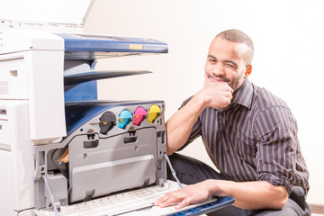 Fototapeta na wymiar smiling technician sitting near copier