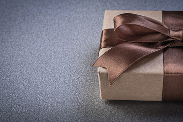 Boxed gift with brown knot on grey background copy space celebra