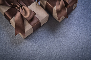 Gift boxes in brown shop paper on grey background celebrations c