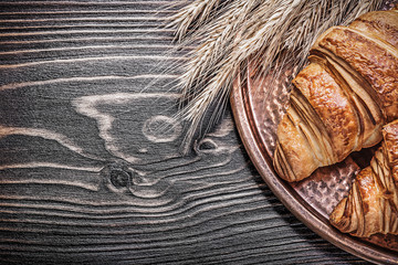 Golden wheat rye ears fresh rolls copper tray on wood board food