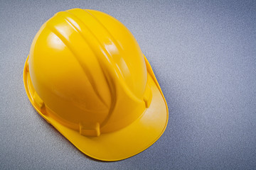 Yellow safety construction helmet on grey background maintenance