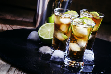Alcoholic cocktail spiced rum with cola, lime and ice cubes, sha