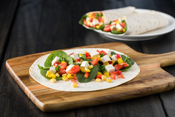 vegan tofu wraps with pepper, corn, tomatoes and spinach