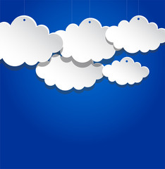 Paper clouds suspended on blue background.