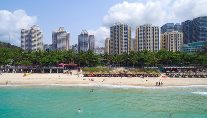 high hotels on beach near green trees and blue sea