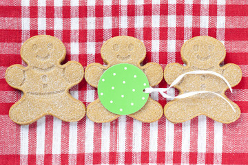image of gingerbread candies arranged over red checkered napkin with a green tag.