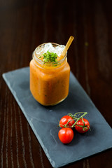 Carrot smoothie served with a cherry tomato