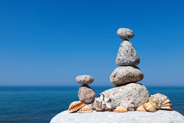 Fototapeta na wymiar Concept of harmony and balance. Rock Zen of seashells on a backg
