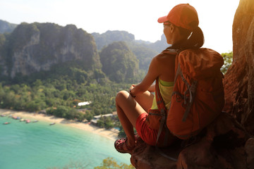 young woman hiker enjoy the view on mountain peak cliff