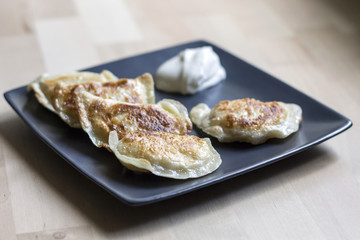 Fried dumplings (called pierogi) with sour cream. Traditional polish food.