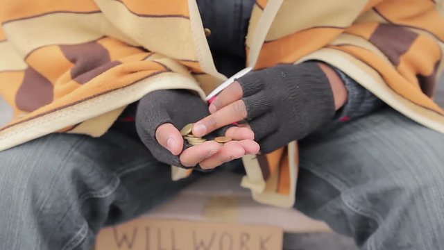 Hands of miserable beggar counting charity money given by kindhearted people