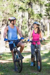 Plakat Young couple riding bicycle at forest