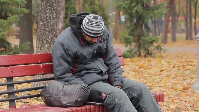 Male drinking addict sleeping on bench in autumn park, alcohol abuse problem