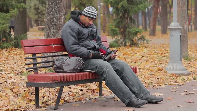 Drunk man sleeping on bench in park with bottle in hand, alcohol use disorder