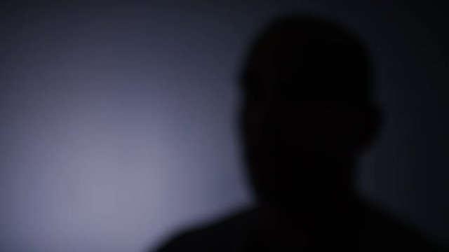 4K Blurred silhouette of anonymous person talking to keep identity concealed, space for text