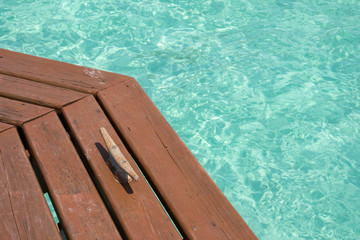 Wooden pier with boat cleat and turquoise water in Belize