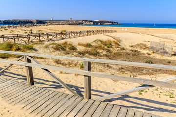 Boardwalk and fence on sandy beach, Tarifa, Spain