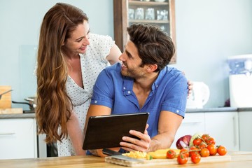 Happy young couple with digital tablet