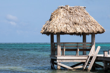Palm frond roof over water in Belize