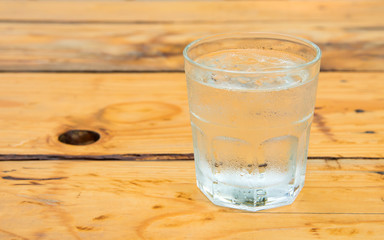 Glass water with ice,Drops water on glass,wooden table.
