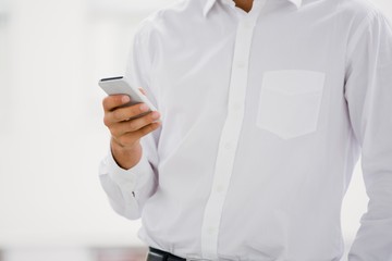 A businessman is holding his smartphone