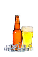 Bottles of beer and glass getting cool in ice cubes on white bac