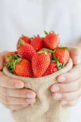 hand hold strawberries sack