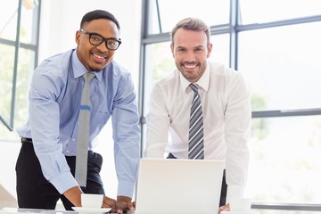 Businessmen using laptop at desk