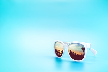 White Sunglasses reflection sunset at palm tree landscape scene