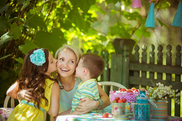 Children kisses his mother in the garden