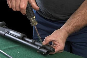 Zelfklevend Fotobehang Gunsmith replacing clamp to barrel on 20 gauge pump action shotgun © sheilaf2002