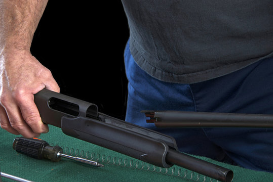 Gunsmith disassembling 20 guage pump action shotgun