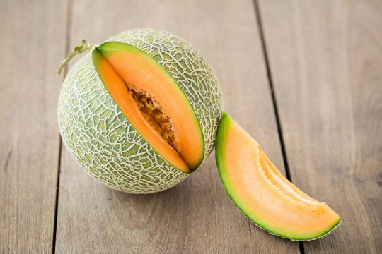 Melon with slices and on a wooden table