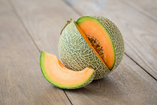 Melon with slices and on a wooden table