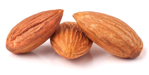 Three almonds isolated on white background macro