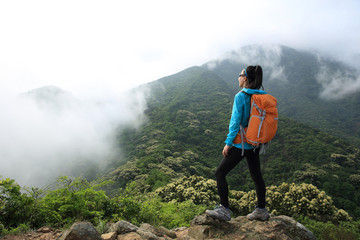 young woman backpacker hiking at forest mountain top