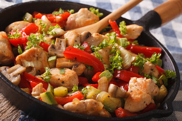 Chinese fried chicken with mushrooms and vegetables in a pan close-up. horizontal
