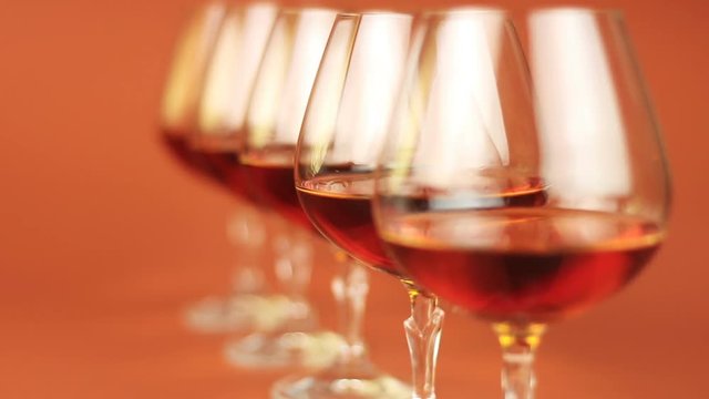Glass of brandy over brown background