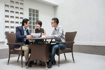 Vietnamese business team having meeting in outdoor cafe
