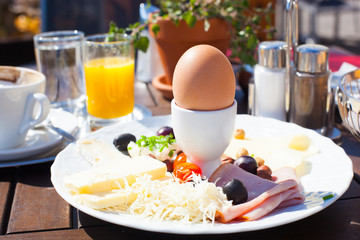 Breakfast consisting of orange juice, tomatoes, bread and egg. Balanced diet