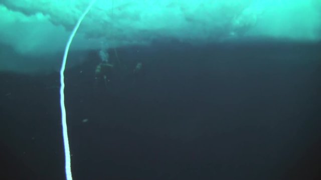 Unique extreme underwater shooting scuba dive beneath ice at geographic  North Pole in cold waters. Fantastic views of the lump of ice in water. ICE CAMP BARNEO, NORTH POLE, ARCTIC - APRIL 2015