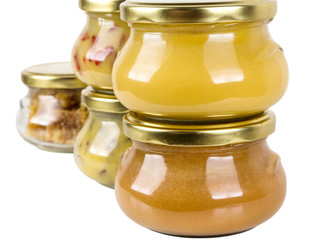 five closed cans with different honey