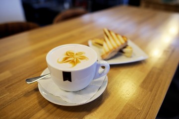 Cup of cappuccino with blur coffee shop background