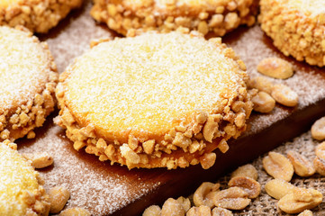 Butter cookies (alfajores) with caramel and peanut on wooden background.