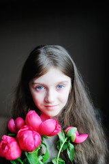 Portrait of beautiful young kid girl  with peonies